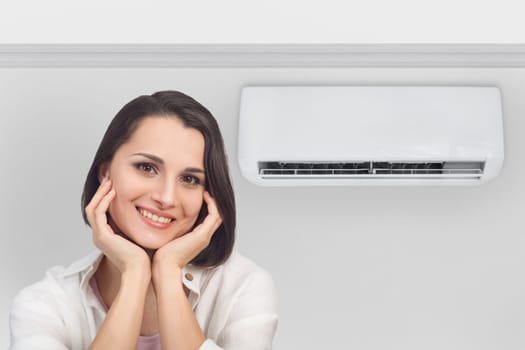 Portrait of a smiling happy woman in a light fresh air-conditioned room, copy space.