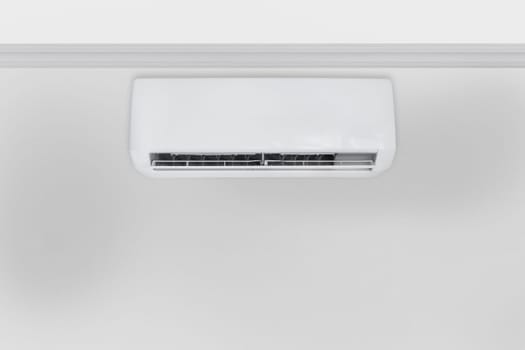 White air conditioner hanging from the ceiling on the wall, big copy space.