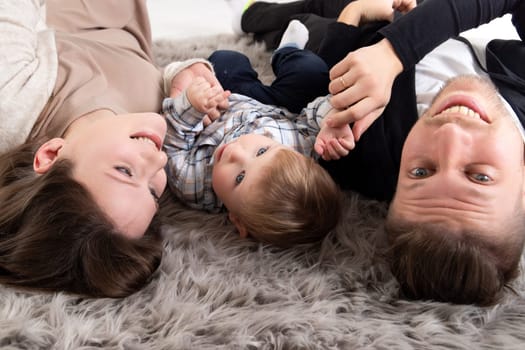 Young happy family have fun together lying on the floor. Close-up portrait.