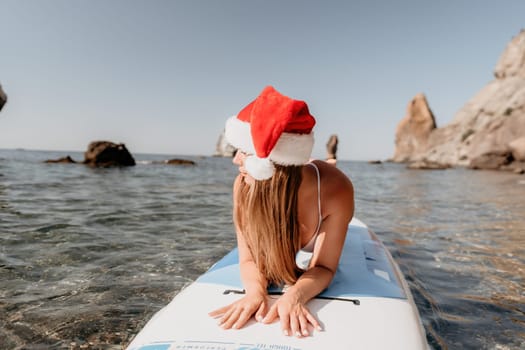 Close up shot of happy young caucasian woman looking at camera and smiling. Cute woman portrait in bikini posing on a volcanic rock high above the sea