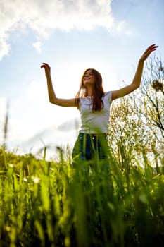 joyful woman posing in tall grass on a sunny day. High quality photo