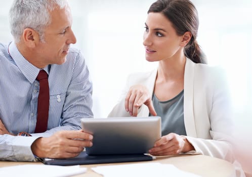 Technology supporting business processes. two coworkers using a digital tablet at work