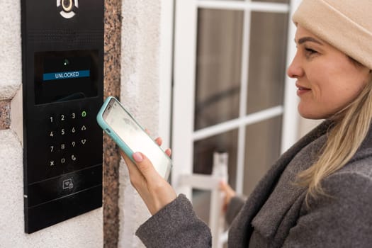 Woman hands using phone scan to digital door lock security systems at home.