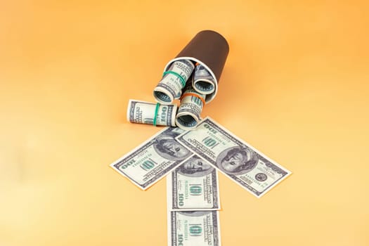 An arrow made of dollar bills points to a paper cup stuffed with wads of money.