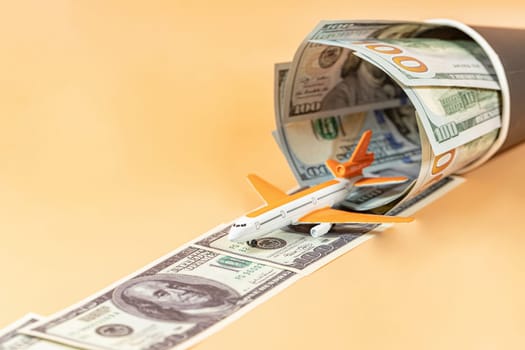 A toy airplane takes off on a runway of dollar bills