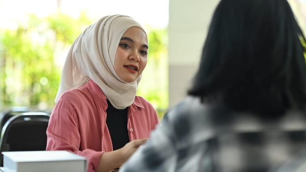 Asian muslim student working on assignment and preparing for exams with her classmates. Youth lifestyle and education concept.