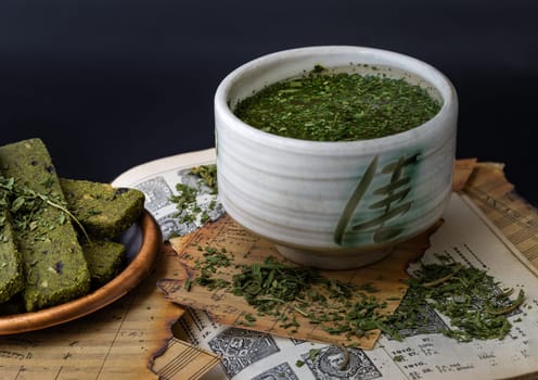 Bangkok, Thailand - Mar 17, 2023 : Enjoy with A Cup of Hemp Tea (CBD herbal tea) is served with the Homemade Cannabis Snack Sticks on the Old Music Notebook. The Concept of Relaxation and the Happiness, Vintage style, Space for text.