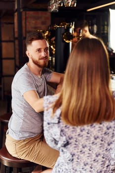 Talking with each other. People in casual clothes sitting in the pub.