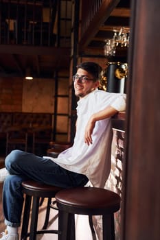 One person. Man in casual clothes sitting in the pub.