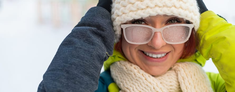 Caucasian woman with glasses smiling and freezing outdoors in winter