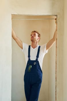 Modern technologies. Young man working in uniform at construction at daytime.