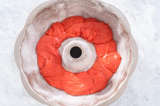 Filling bundt cake pan with red, white, and blue cake dought to bake July 4th bundt cake with chocolate stars.