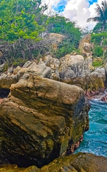 Extremely beautiful huge big surfer waves rocks cliffs stones and boulders on the beach in Zicatela Puerto Escondido Oaxaca Mexico.