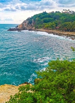 Extremely beautiful huge big surfer waves rocks cliffs stones and boulders on the beach in Zicatela Puerto Escondido Oaxaca Mexico.