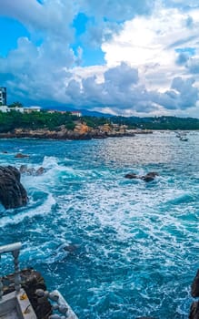 Extremely beautiful huge big surfer waves rocks cliffs stones and boulders on the beach in Zicatela Puerto Escondido Oaxaca Mexico.