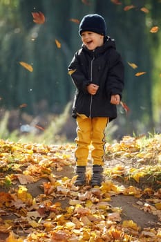 Adorable child boy with leaves in autumn park. The concept of childhood, family and kid.