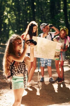 With touristic equipment. Kids strolling in the forest.