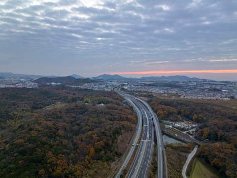 Empty road through small town toward distant hills with predawn color in sky. High quality photo