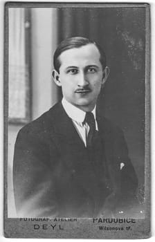 PARDUBICE, CZECHOSLOVAKIA - CIRCA 1920: Vintage cabinet card shows portrait of the young man. Photo was taken in a photo studio.