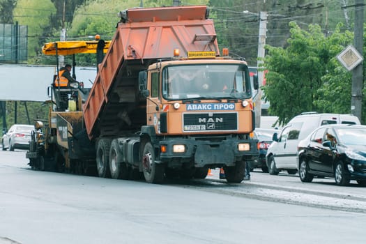 Team of workers in protective uniforms work on road construction. Workers transportation equipment construction industrial machine building