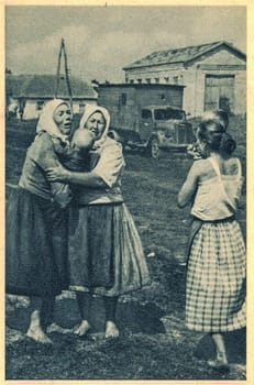 UKRAINE - 1942: The victims of war. Crying women with children.