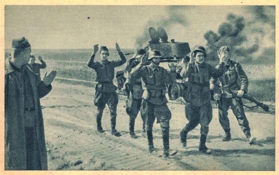 RUSSIA - JUNE 22, 1941: German forces launched Operation Barbarossa, the Axis invasion of the Soviet Union. The Soviet soldiers are captured by German troops. On the background is detroyed an army tank