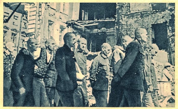 LENINGRAD - 1944: The siege of Leningrad was a prolonged military blockade undertaken from the south by the Army Group North of Nazi Germany against the Soviet city of Leningrad (now Saint Petersburg) on the Eastern Front in World War II. In the photo, German war prisonerss head shaved go along the street of Leningrad.