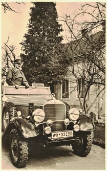 LEONDING, AUSTRIA - MARCH 13, 1938: Adolf Hitler poses in Mercedes car in Leonding. From 1898 to 1905 Adolf Hitler lived in Leonding where he attended the local primary school and later a grammar school in nearby Linz. The graves of his parents Alois and Klara are in Leonding. His brother Edmund, who died of measles, was buried there too