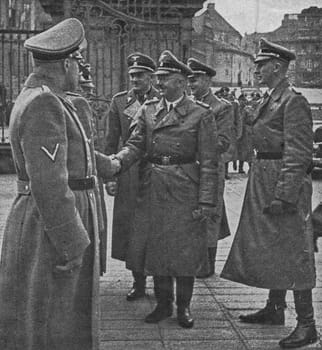PRAGUE, PROTECTORATE OF BOHEMIA AND MORAVIA - OCTOBER 1941: Reichsfuhrer Heinrich Himmler greets others nazis at Prague castle. On the right is Reinhard Heydrich.