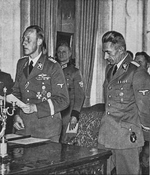 PRAGUE, PROTECTORATE OF BOHEMIA AND MORAVIA - CIRCA 1942: Reinhard Heydrich (left) with Karl Hermann Frank. Heydrich gives a speech to audience.