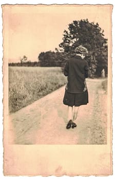 GERMANY - CIRCA 1960s: Retro photo shows woman goes for a walk. Black and white photography from the golden sixties.