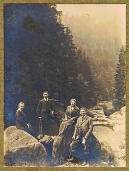 GERMANY - CIRCA 1920s: Vintage photo shows men and women pose outdor during for a walk in the mountains. Antique black and white studio portrait.