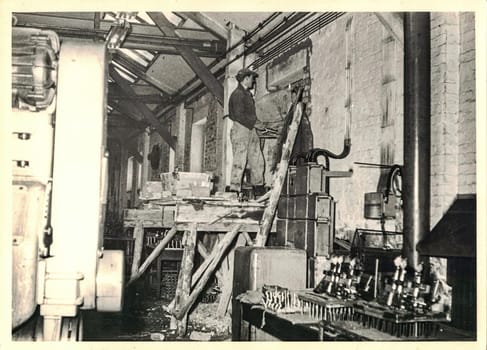 FRAUREUTH, EAST GERMANY - MARCH 3, 1965:The retro photo shows bricklayer working. Authentic photo from Communist Bloc