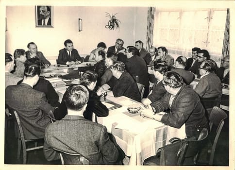 FRAUREUTH, EAST GERMANY - MAY 6, 1965: The retro photo shows company meeting in Communist bloc. Former East Germany, 1960s.