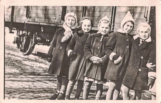 GERMANY - CIRCA 1960s: The retro photo shows the group of small girls outsides. Fife little girl-children in winter time.