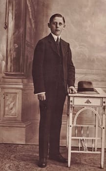 GERMANY - CIRCA 1920s: Vintage photo shows an elegant boy wears black suit. Black and white antique photography.