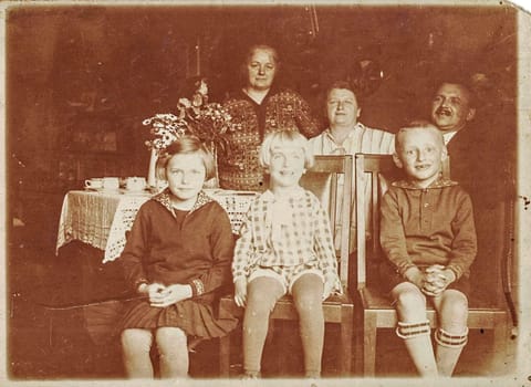 GERMANY - JUNE 5, 1929: Vintage photo shows family and festive table. Sepia black and white photography. Circa 1930s