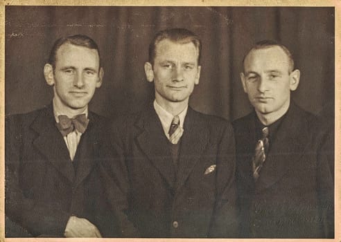 BAD BRAMSTEDT, GERMANY - OCTOBER 27, 1946: The vinage photo shows three young men. Studio black and white portrait.