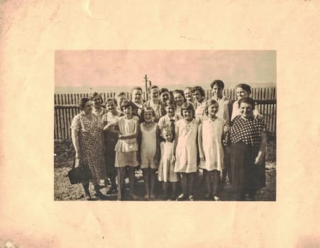 GERMANY - CIRCA 1950s: Retro photo shows group of people pose in backyard. Mostly women and girls on the photo. Group of relatives.