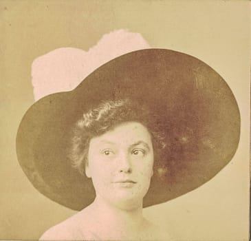 GERMANY - 1910: Vintage photo shows dreamy portrait of woman. Woman wears ladies hat, the neck and body is hand painted additionally, the ladies hat too. Black & white antique photography.