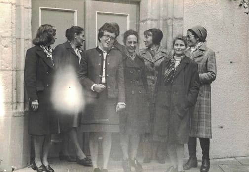 GERMANY - CIRCA 1960s: Retro photo shows group of ladies pose in front of building. Photo has imperfection.