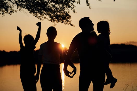 Love gesture. Family of mother, father and kids is on the camping.