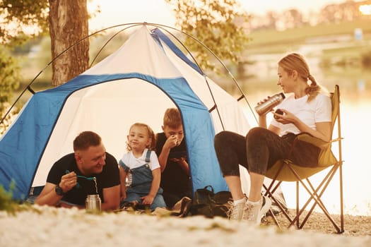Conception of vacation. Family of mother, father and kids is on the camping.
