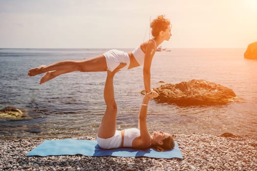 Woman sea yoga. Back view of free calm happy satisfied woman with long hair standing on top rock with yoga position against of sky by the sea. Healthy lifestyle outdoors in nature, fitness concept.