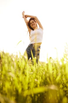 a woman on a bright sunny summer day standing in a yellow field. High quality photo