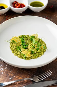 Pea risotto on a white porcelain plate in a fine dining restaurant