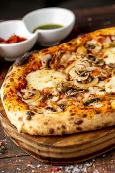 Cheese and mushroom pizza with toppings on the cutting board