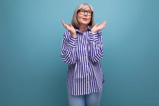 youth 60s middle-aged woman with gray hair on a bright studio background with copy space.