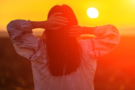 Woman back against sunset and wild tulip flowers, natural seasonal background. Multi-colored tulips Tulipa schrenkii in their natural habitat are listed in the Red Book