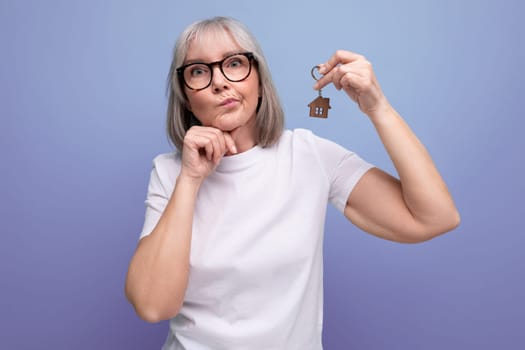 social insurance. mature woman holding secure keys on studio background.